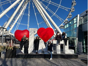 People posing around a big J'aime MTL sign in Montreal's Old Port.
