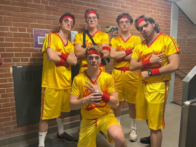 Five Bishop's students wearing yellow sport uniforms and posing for the camera.