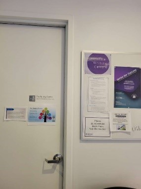 A white door indicating it's the Writing Centre and a number of posters about services.