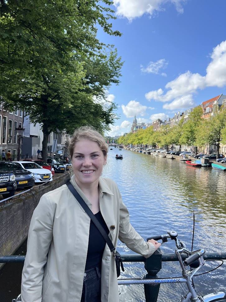 Girl with a bike by a canal in Amsterdam.