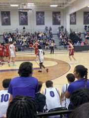 View from the seats at a basketball game with players on the court.