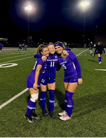 Friends playing soccer dressed in purple